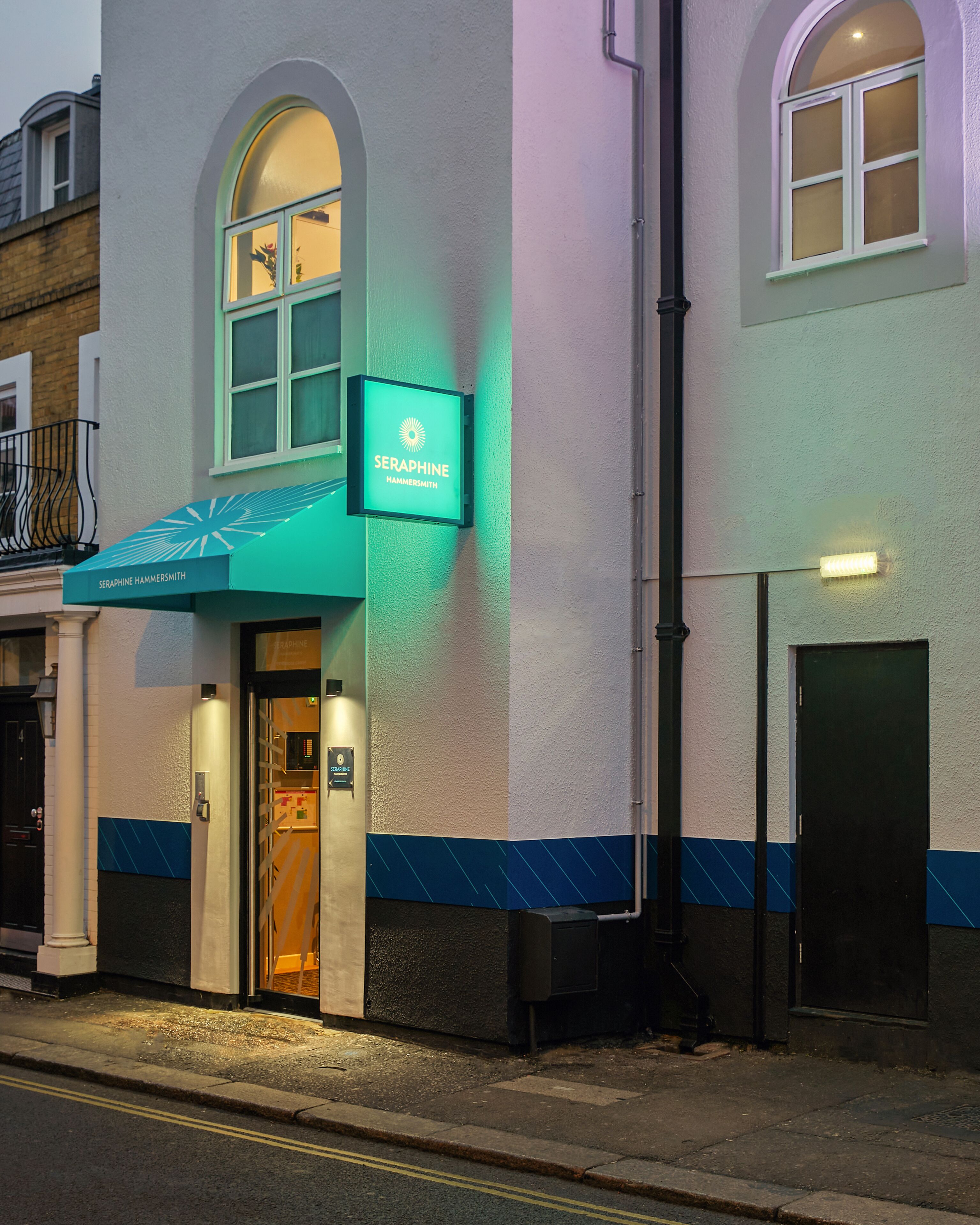 A hotel entrance with a sign reading "Seraphine Hammersmith" and a green awning.