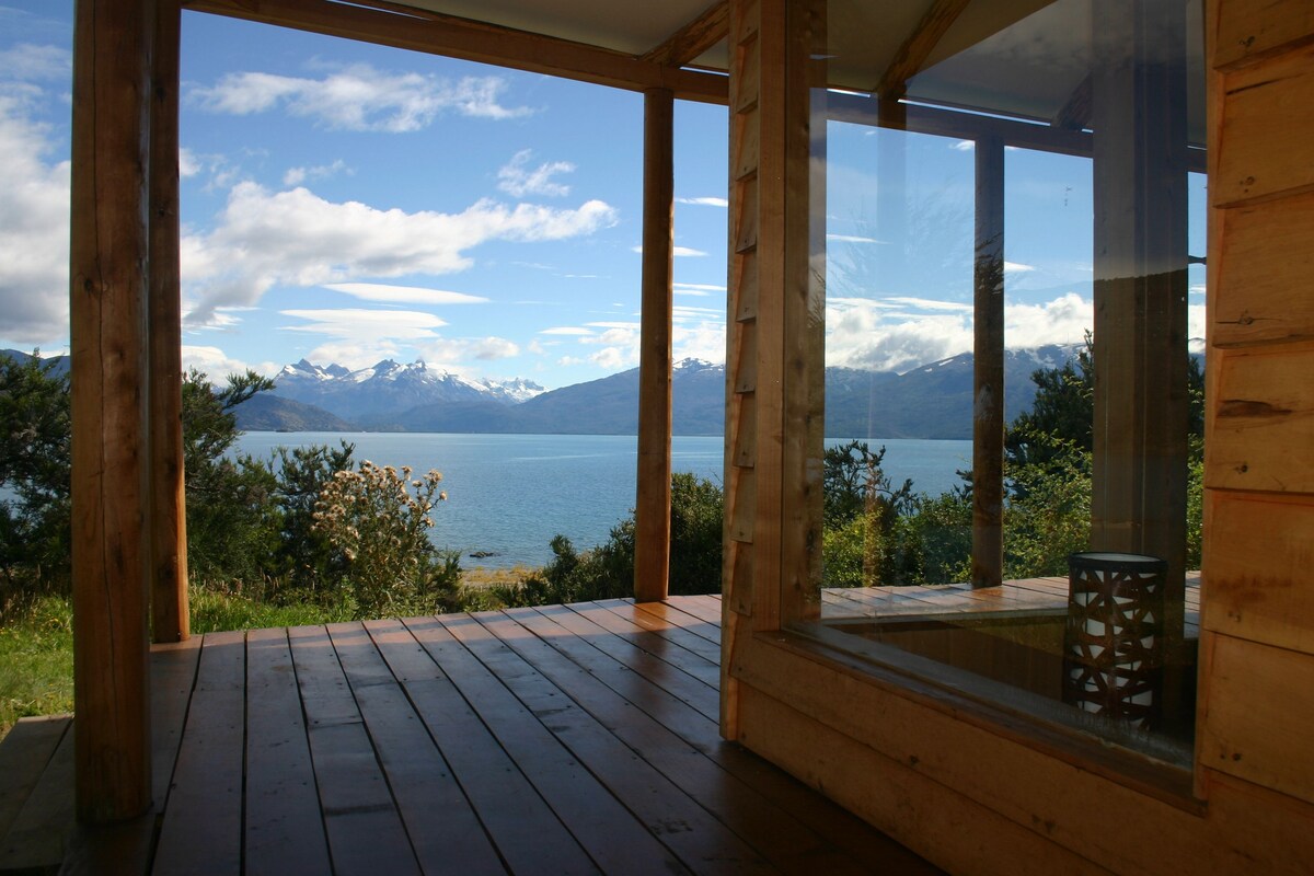 A wooden deck with a view of a lake and mountains.