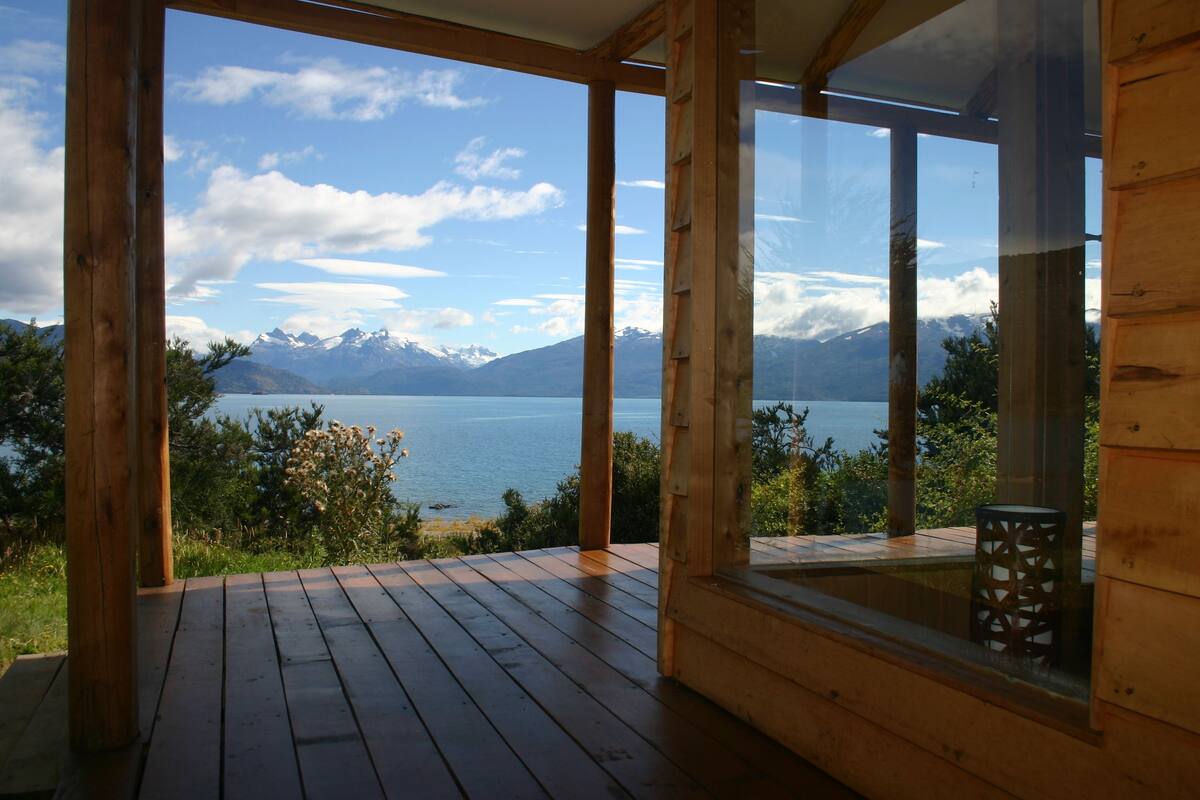 A wooden deck with a view of a lake and mountains.