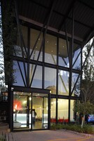 A modern hotel with large glass windows and a reception area.