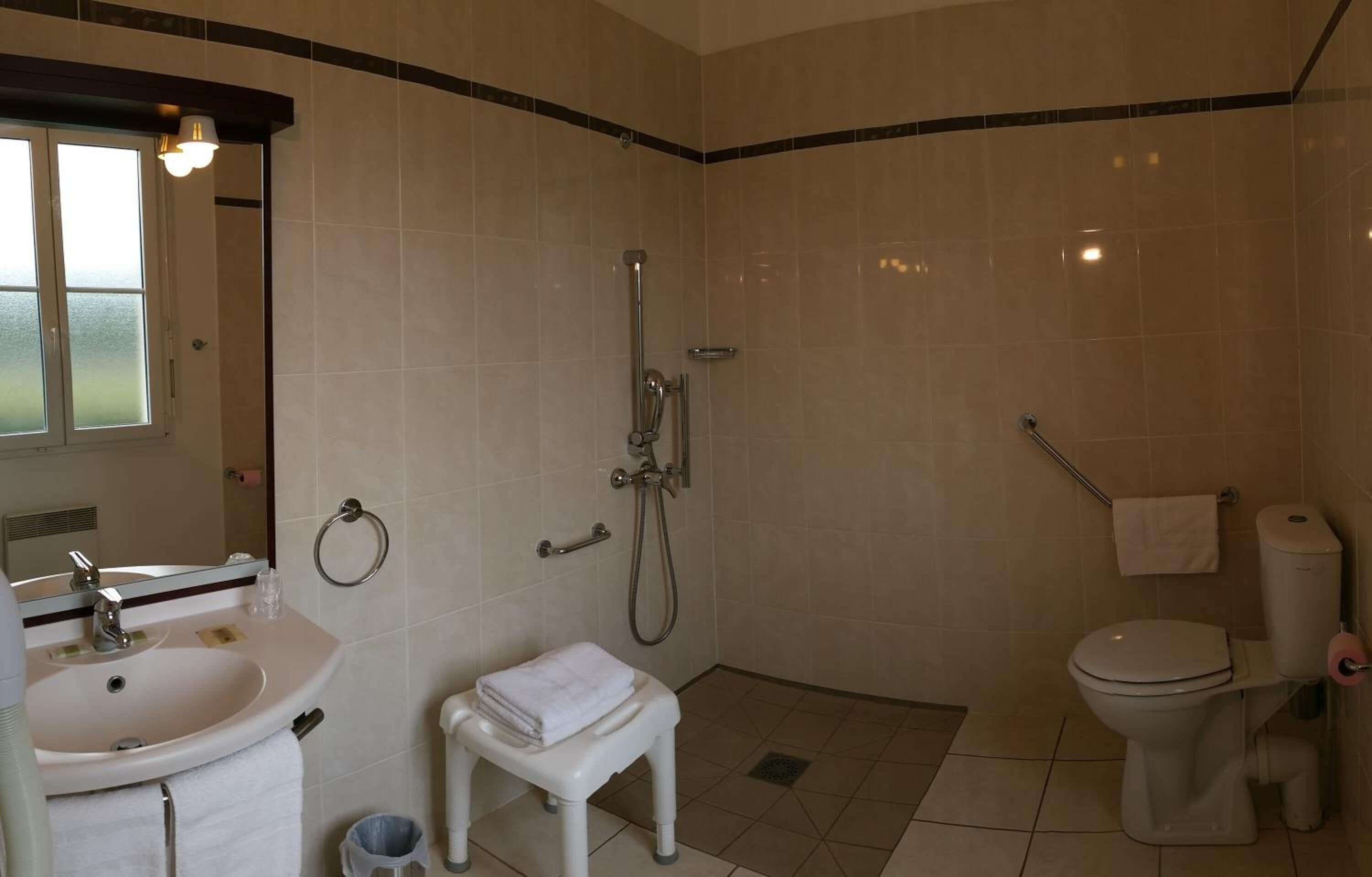 Un baño con lavamanos, inodoro y ducha.