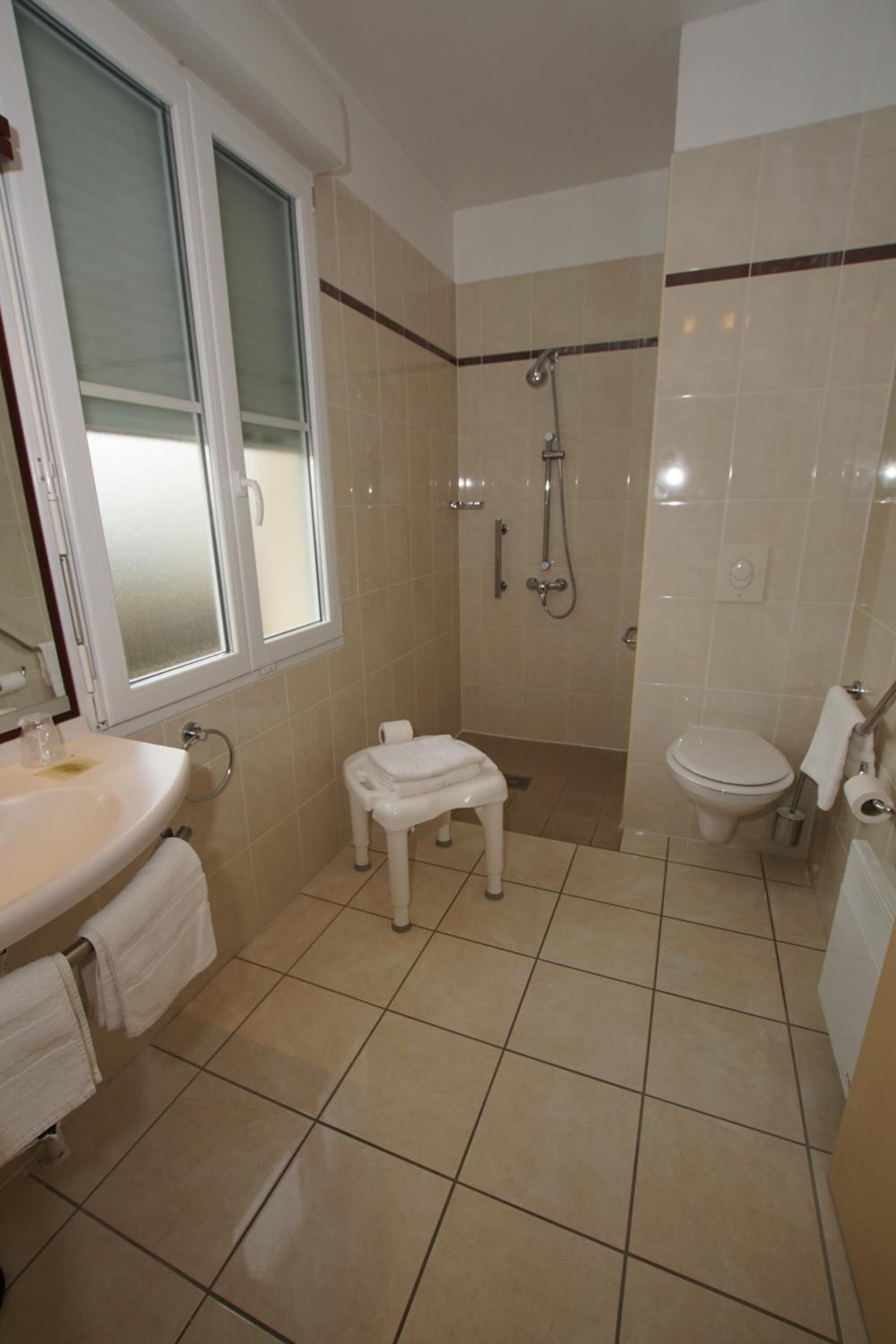 Une salle de bain comprenant des toilettes, un lavabo et une douche.