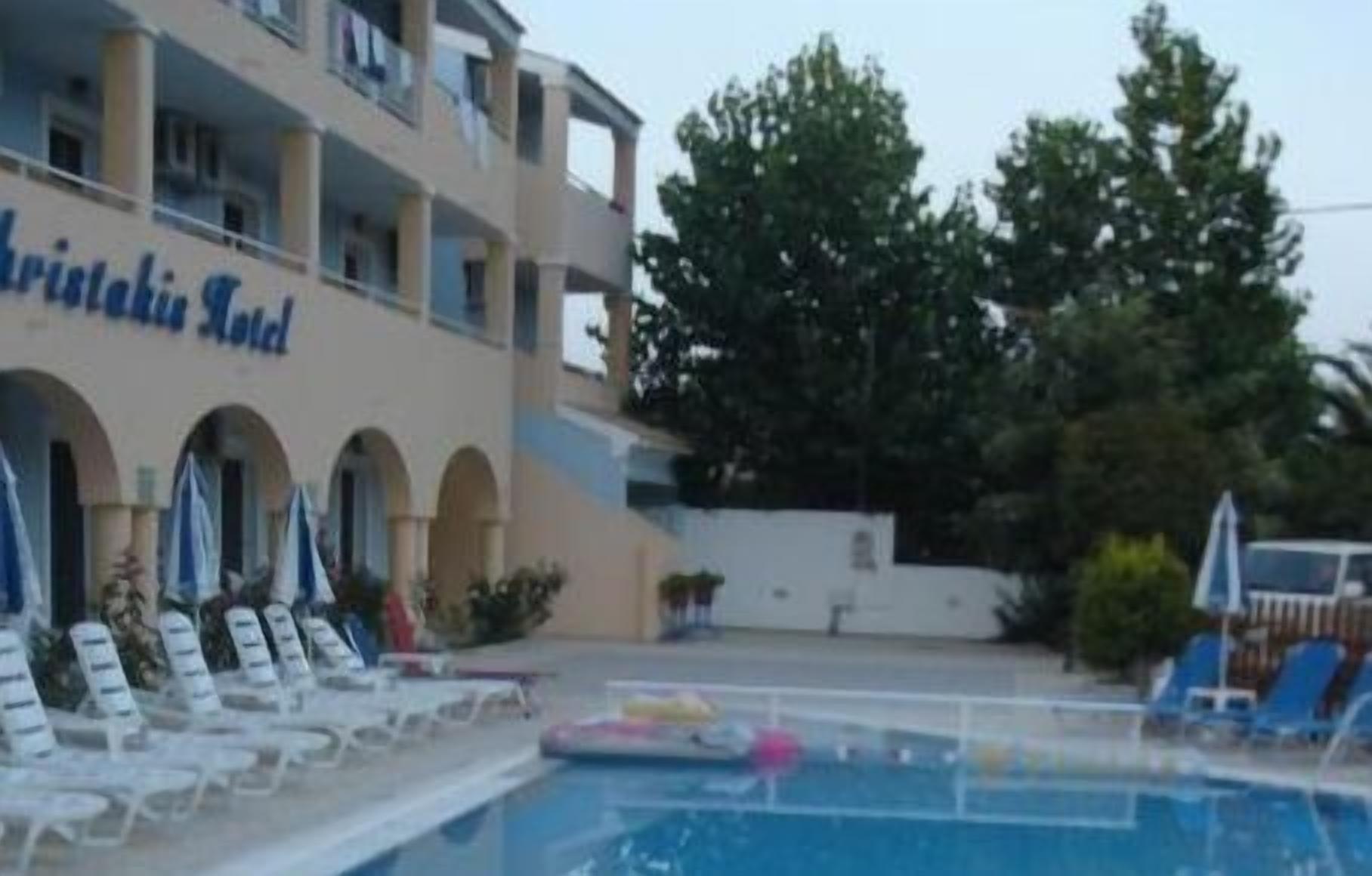 Et hotel med swimmingpool, udendørs siddepladser og en bygning med altaner.