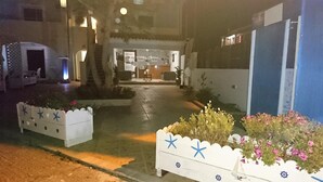 A hotel entrance with a reception desk, a staircase leading to the upper floor, and decorative planters with star-shaped cutouts. - Christakis Hotel (Corfu)