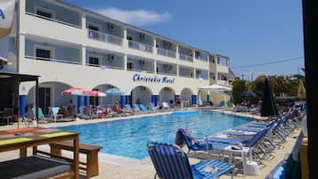Relax by the large outdoor pool surrounded by lounge chairs and umbrellas.