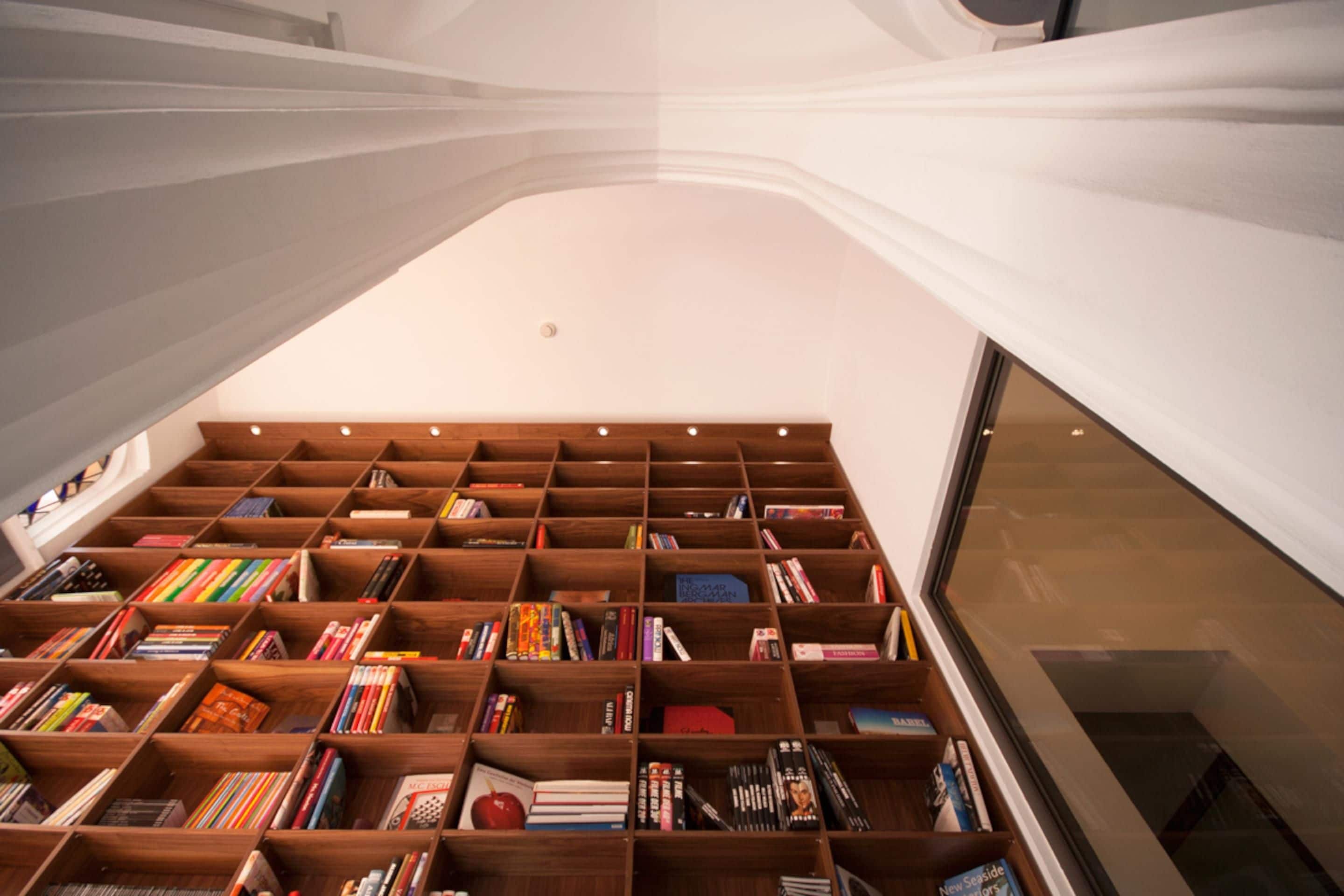 A library with wooden bookshelves filled with books.