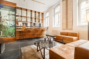 A modern interior with a bar area, seating, and a large aquarium. - Hopper Hotel St. Josef, WorldHotels Crafted (Cologne)