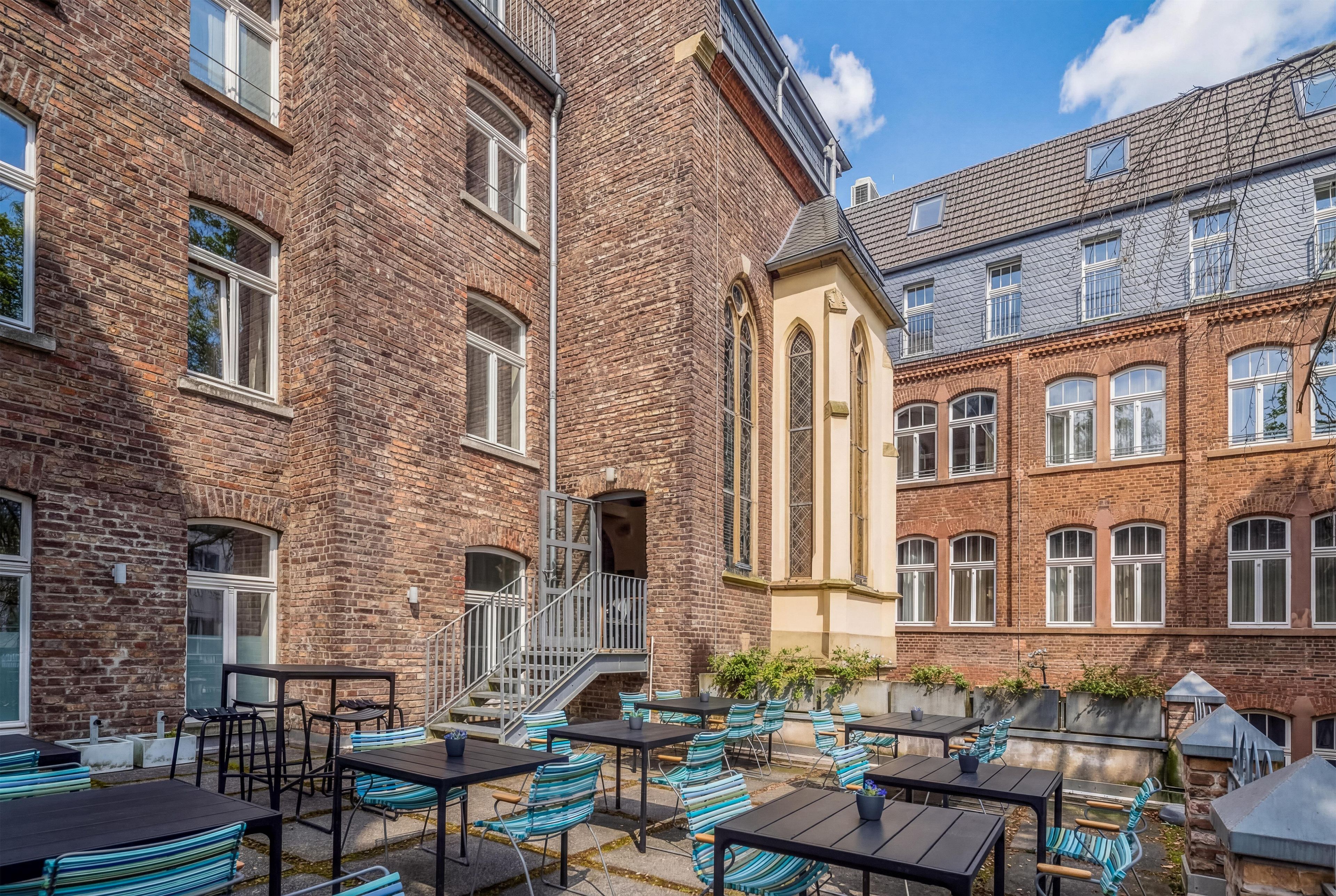 A courtyard with outdoor seating and a staircase leading to an upper level.