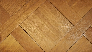 Primer plano de un suelo de parqué de madera con un diseño en espiga.