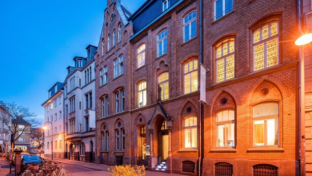 A historic building with arched windows and a prominent corner tower. - Hopper Hotel St. Josef, WorldHotels Crafted (Cologne)