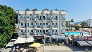 A multi-story hotel with balconies, a pool area, and outdoor seating. - Reis Maris Hotel (Marmaris)