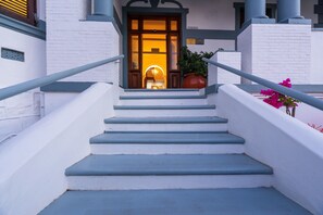 A staircase leading to a building entrance with a potted plant and flowers on the side. - Esperanza Guest House (Cape Town)