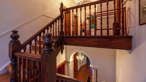 A wooden staircase with a chandelier and a red and white patterned lamp. - Esperanza Guest House (Cape Town)