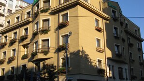 A multi-story hotel with balconies adorned with flower boxes. - Hotel Irisa (Bucharest)
