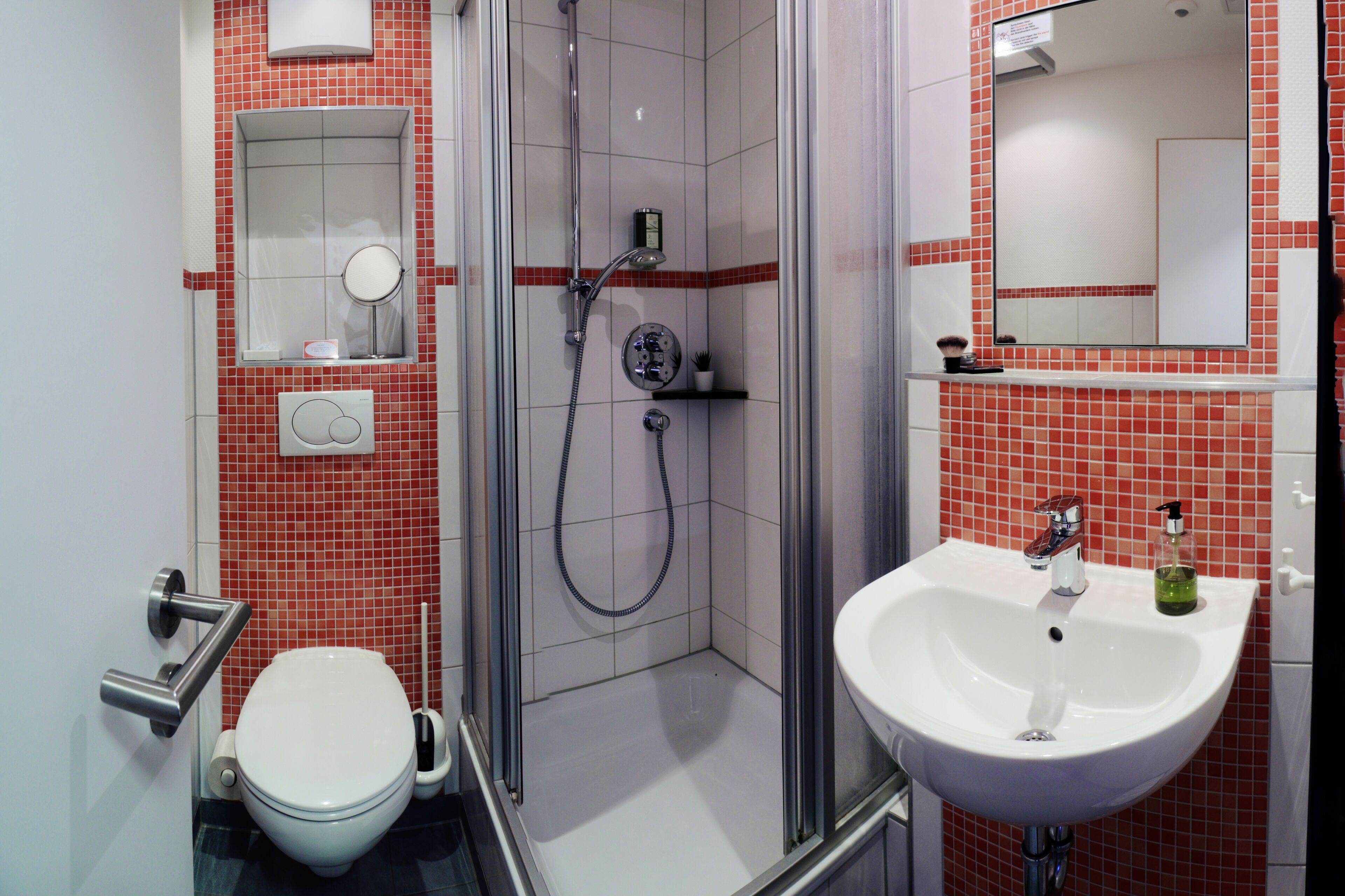 Een badkamer met toilet, douche en wastafel.
