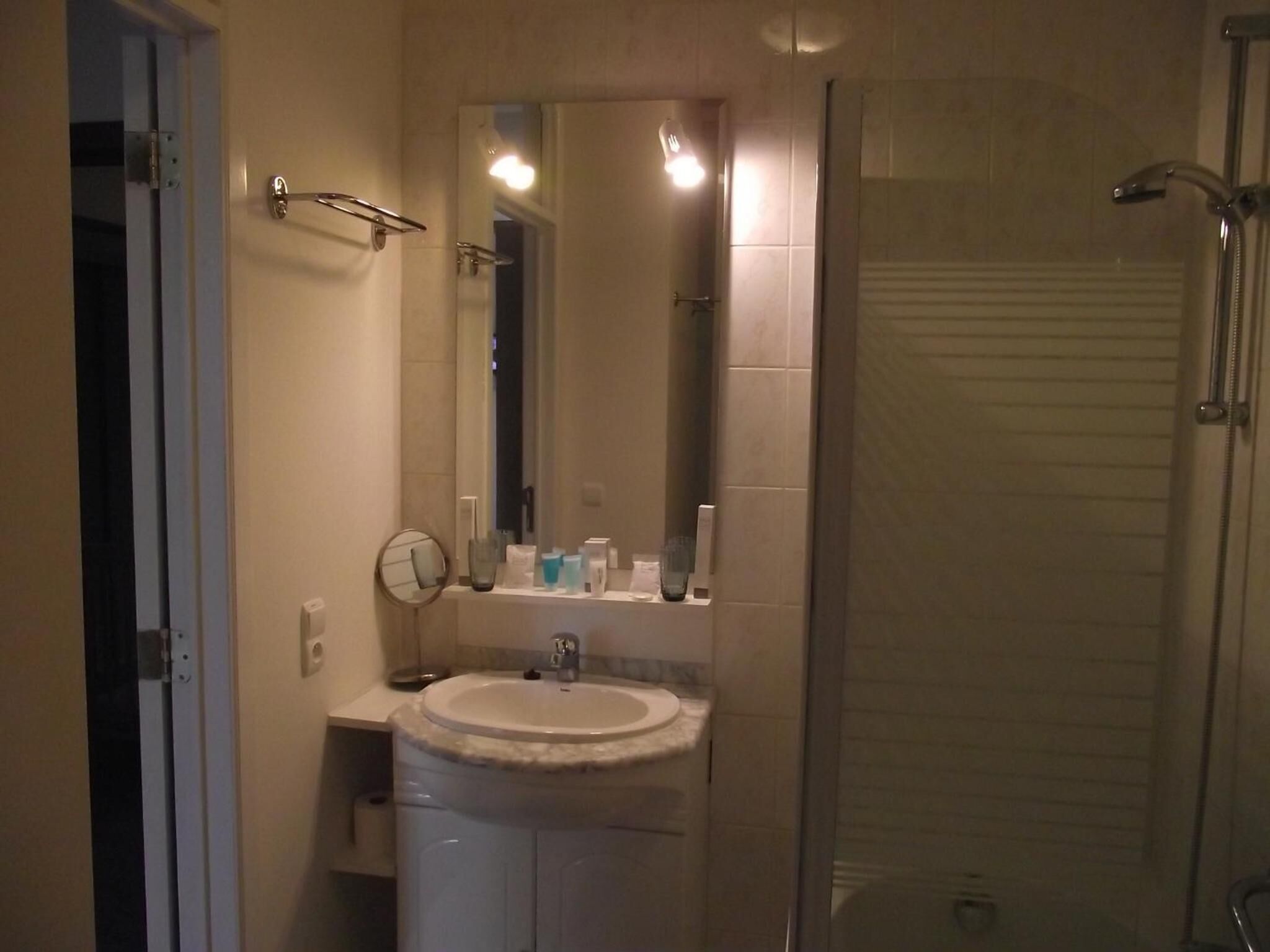 Un baño con lavabo, espejo y ducha.