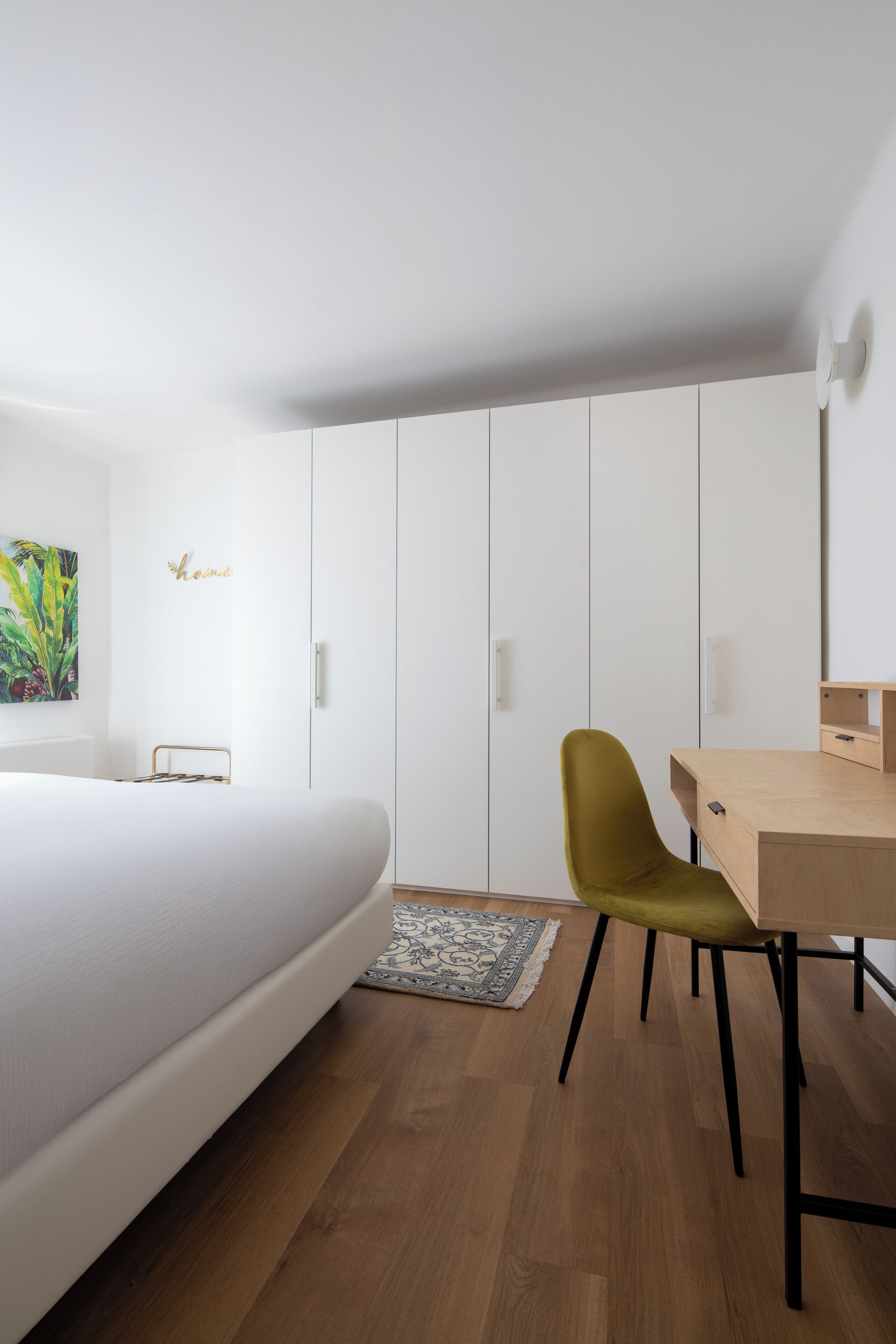 Quarto com cama, escrivaninha, cadeira e guarda-roupa.