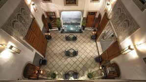 An indoor courtyard with a central seating area, patterned walls, and wooden doors. - Riad Layla (Fes)
