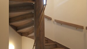 A spiral staircase with wooden steps and metal handrails, leading to an upper floor. - Pension Krivá (Olomouc)