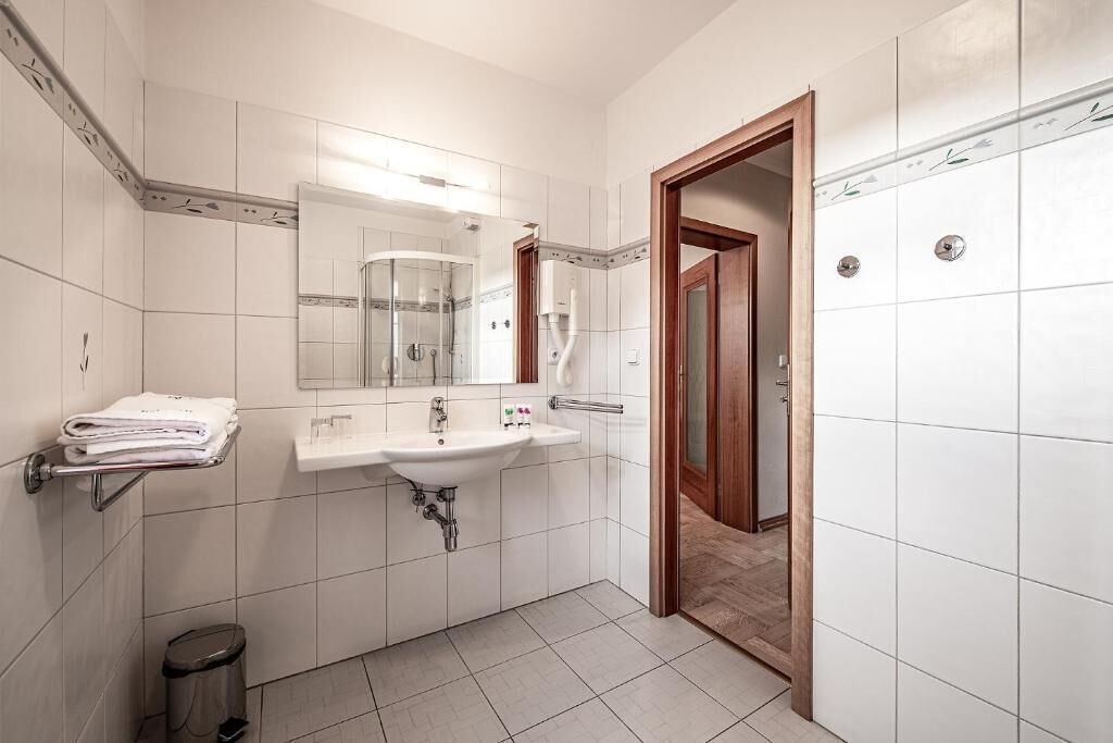 Un baño moderno con lavamanos, espejo y ducha.