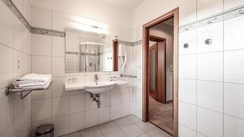 Un baño moderno con lavamanos, espejo y ducha.