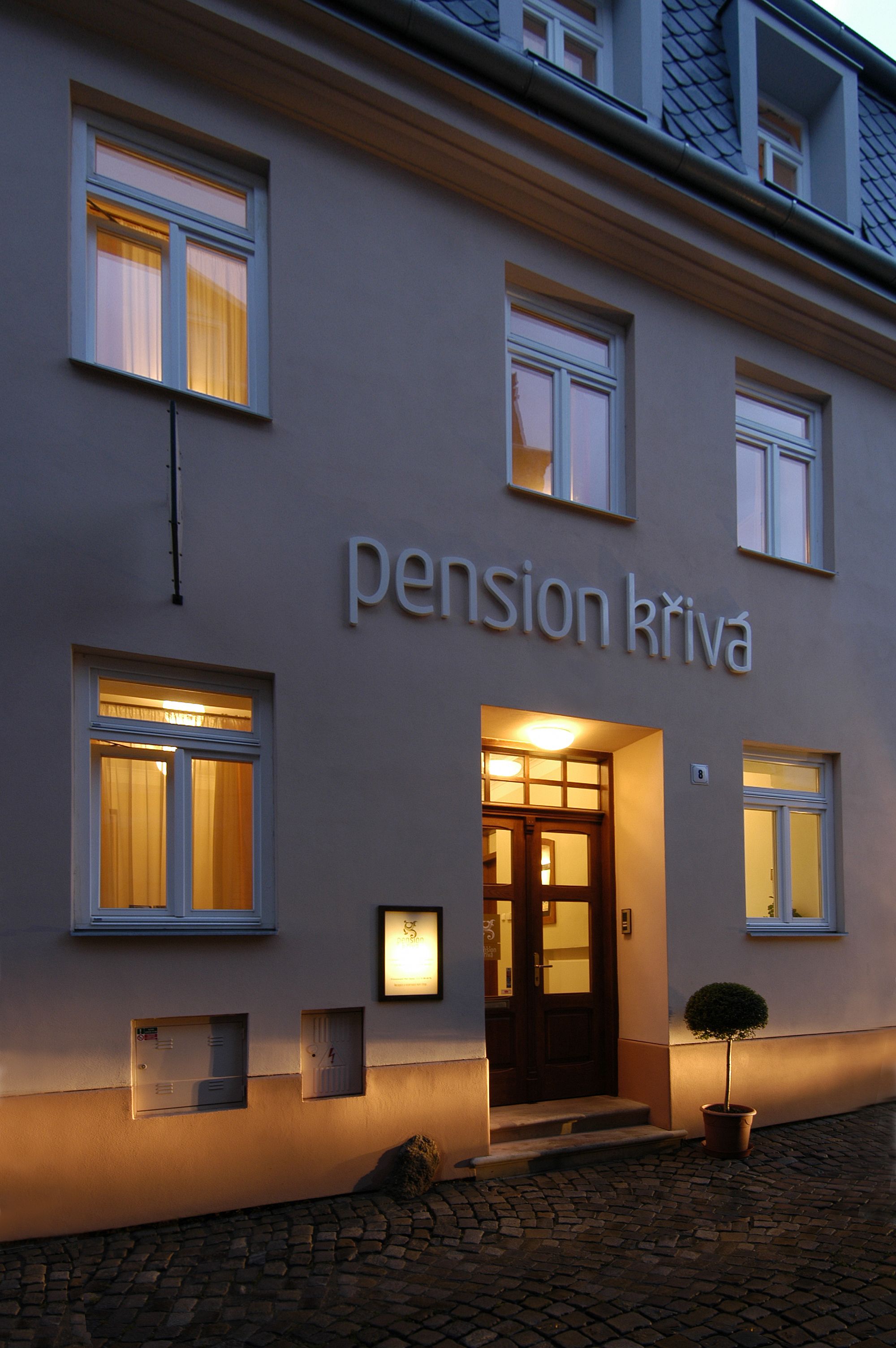 A building with the sign "pension kriva" indicating a lodging establishment.