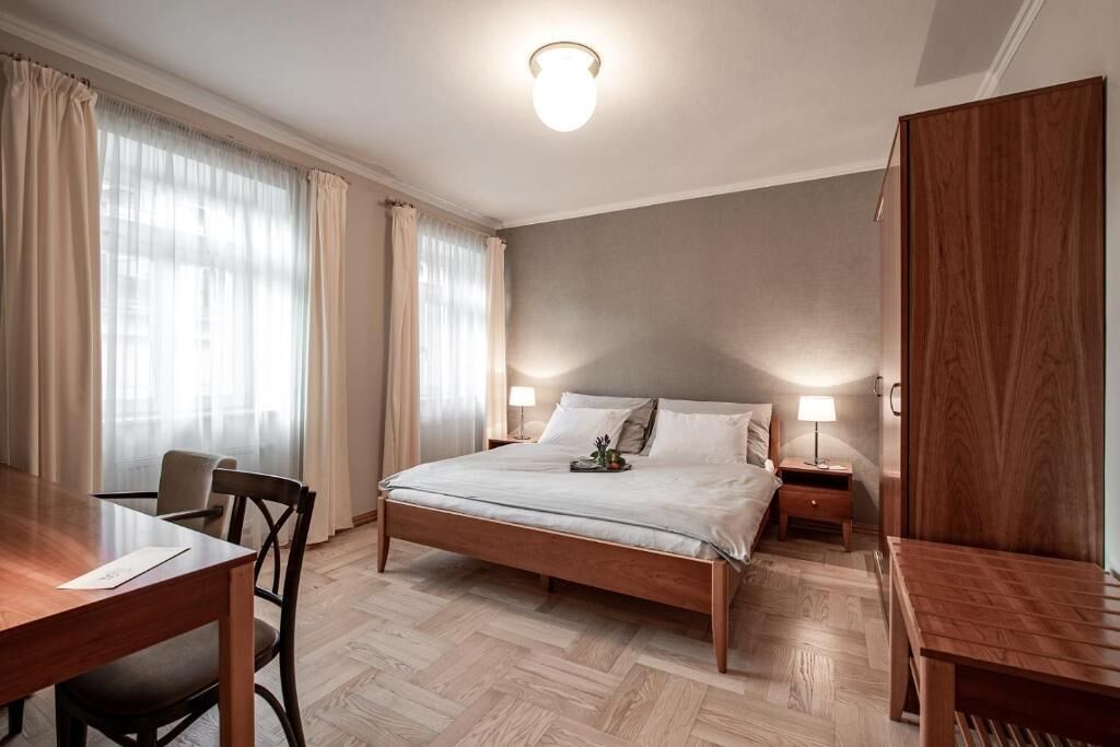 A bedroom with a wooden bed, a desk, and a chair.