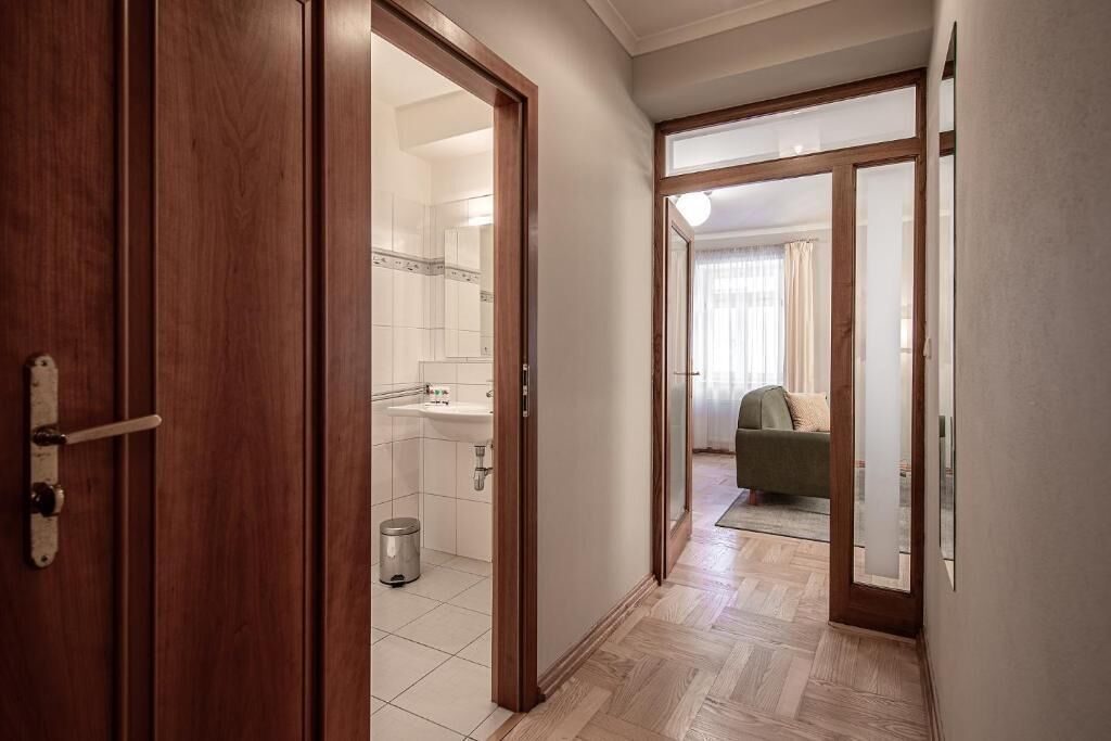 A hallway leading to a bathroom with a sink and toilet.