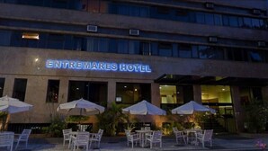 The exterior of the Entremarés Hotel with outdoor seating and umbrellas. - Entremares Hotel (Rio de Janeiro)