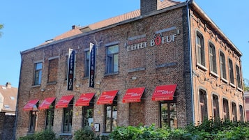 Een bakstenen gebouw met meerdere rode luifels waarop