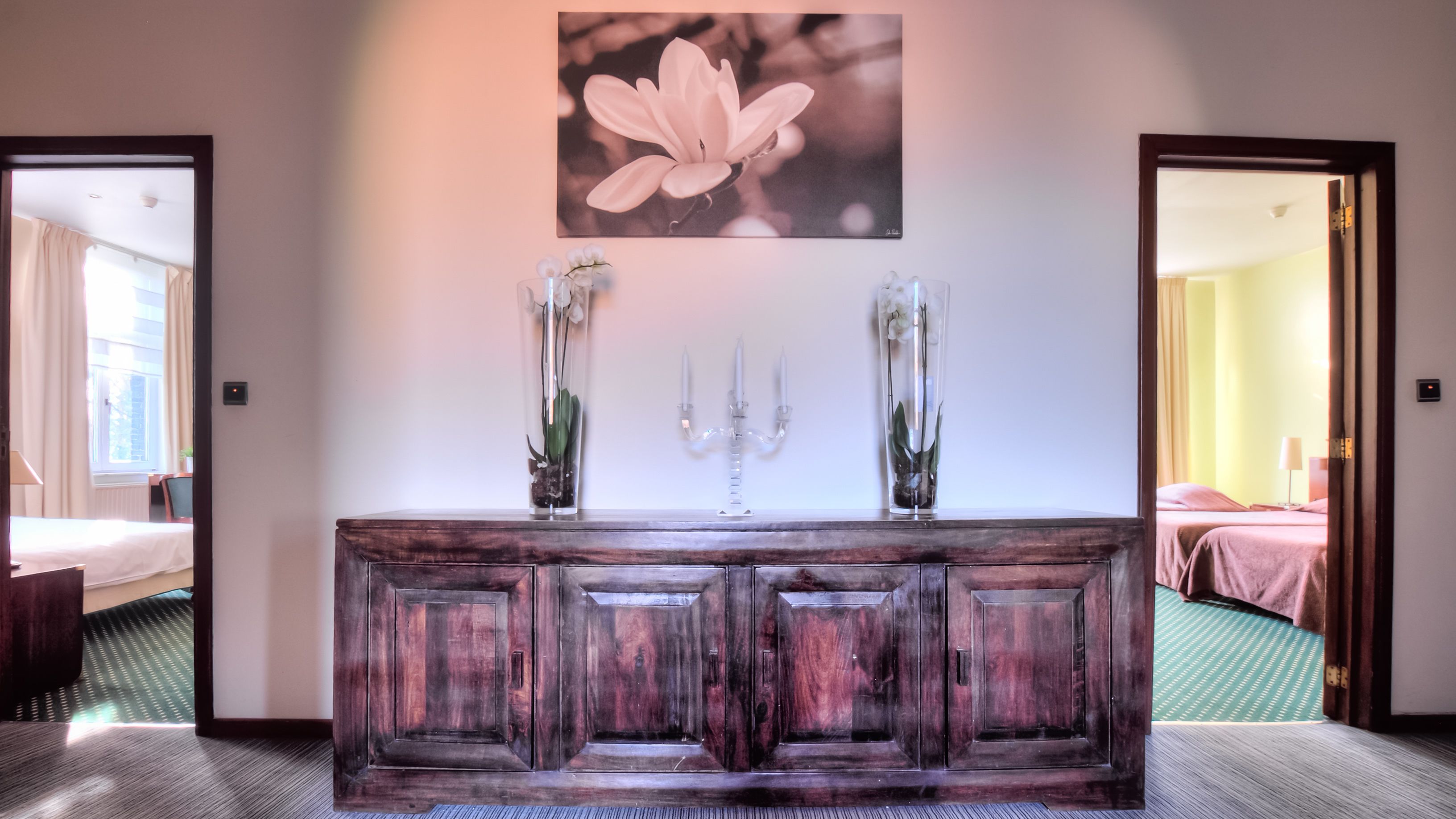 Un taulell de recepció de fusta amb un candelabrum i dos vas de flors.