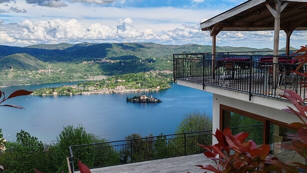 A terrace with a view of a lake, mountains, and a gazebo. - Hotel Panoramico lago d'Orta adults only (Madonna del Sasso)