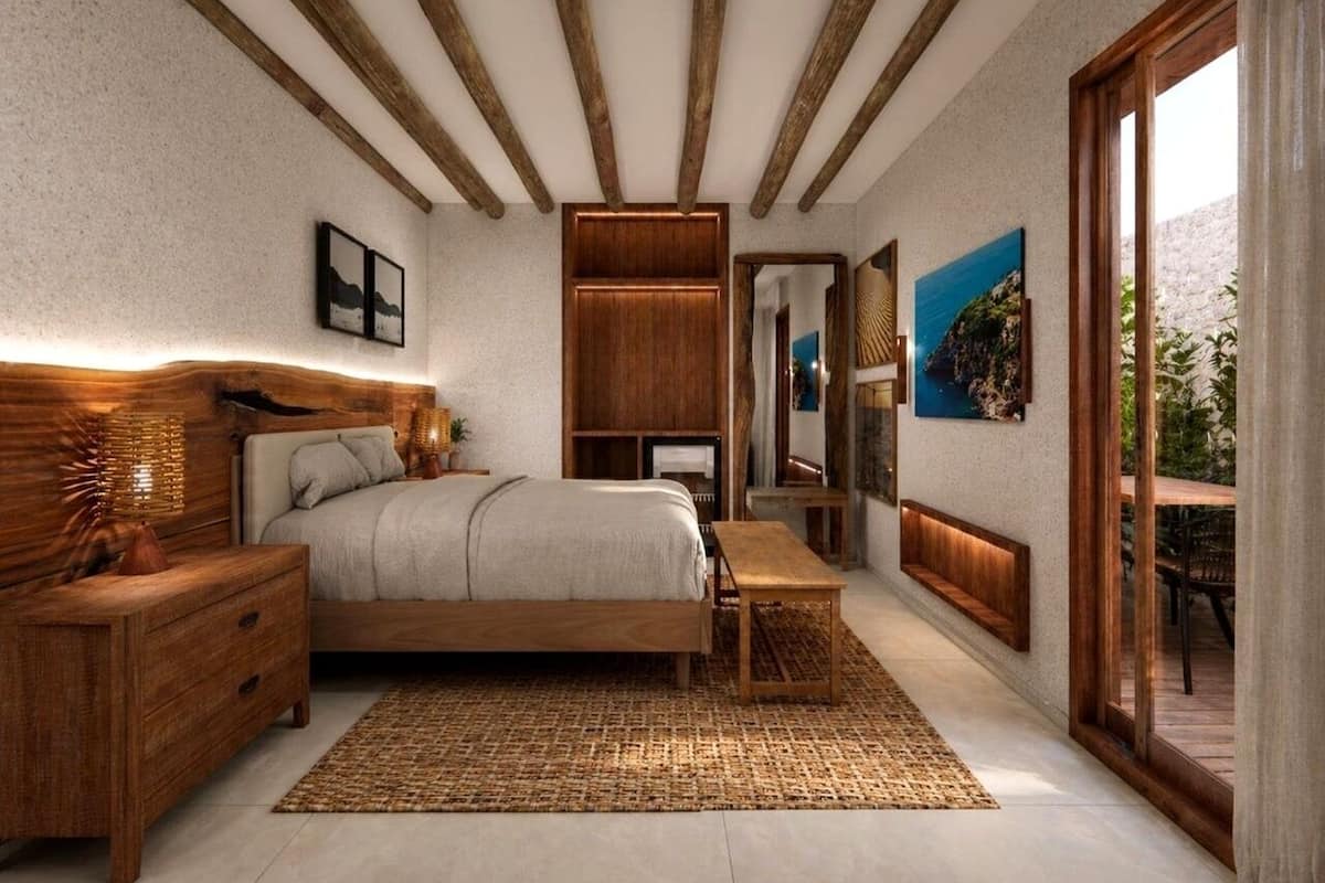 Een slaapkamer met een bed, nachtkastjes, een bankje, een spiegel en kunstwerken aan de wanden.
