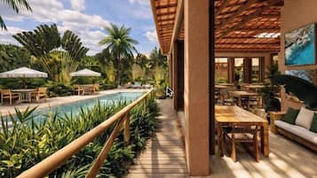 Una piscina al aire libre, sombrillas, tumbonas