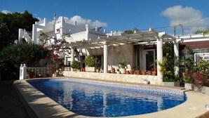 A swimming pool with a white pergola and potted plants. - Hostal La Paloma I (Calpe)