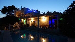 A hotel with a pool, outdoor seating, and a sign that reads "HOSPITAL". - Hostal La Paloma I (Calpe)