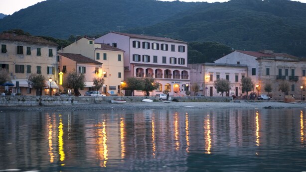 A waterfront view of buildings with reflections on the water. - Hotel Marinella (Marciana Marina)