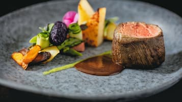 A plate with a steak, vegetables, and a slice of bread.