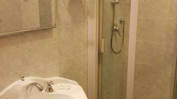 Un baño con lavamanos, espejo y ducha.