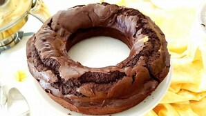 Un pastel de chocolate con forma de anillo sobre un plato blanco.