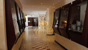 A hotel corridor with checkered flooring, large mirrors, and a 'Milotto Hotel & Plus' sign. - Hotel Miletto (San Massimo)