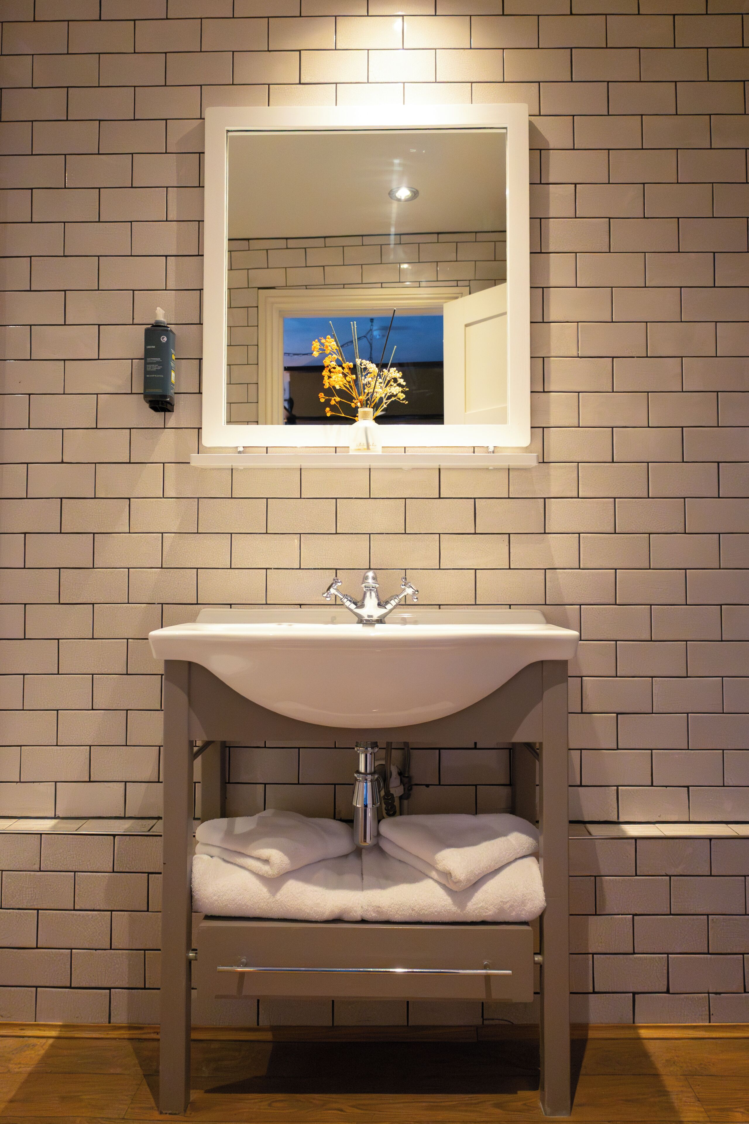 Une salle de bain avec un lavabo blanc, un miroir et un porte-serviettes.