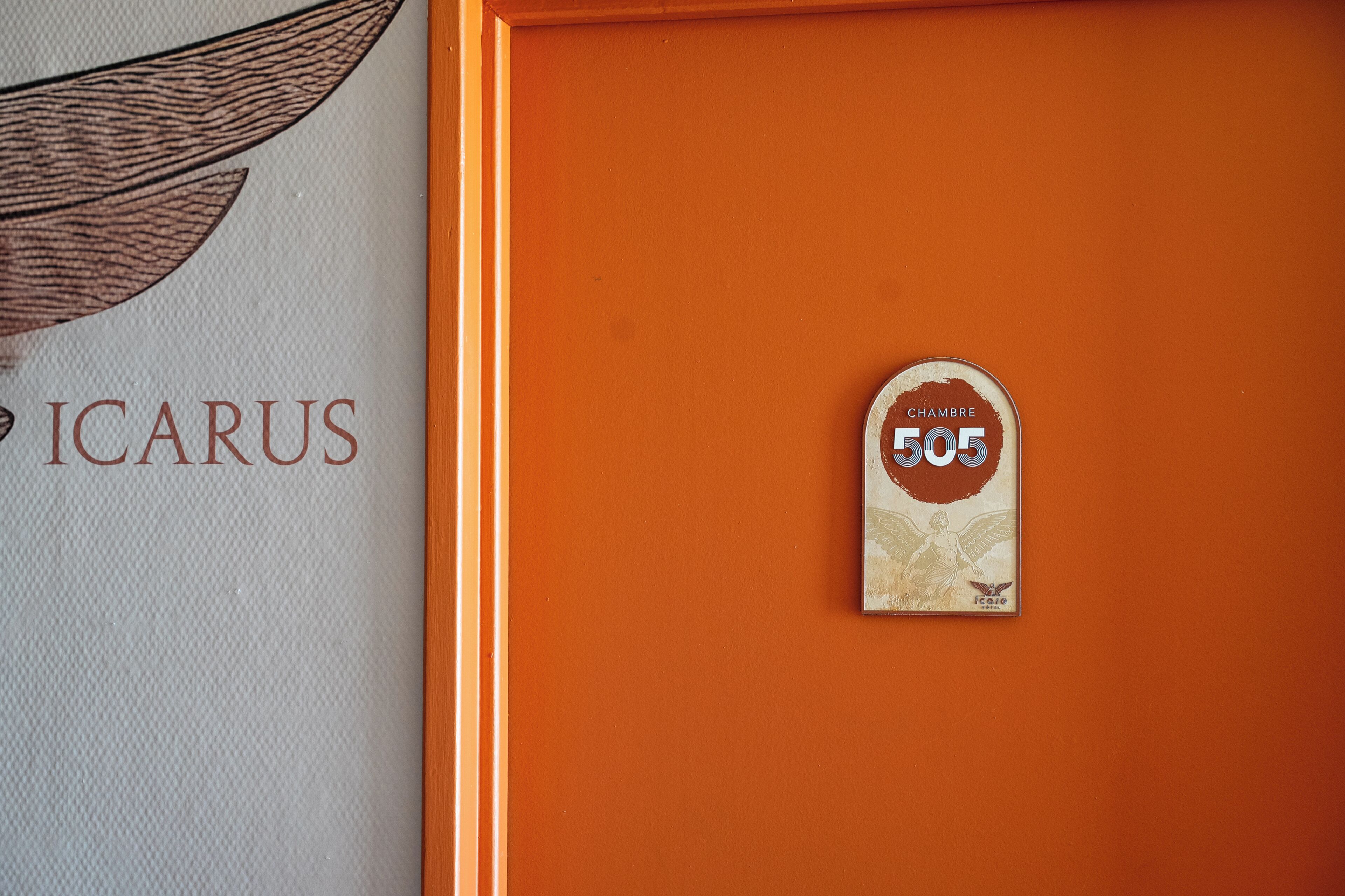 A wall with a sign reading 'ICARUS' and a door with a circular sign labeled 'CHAMBRE 505'.