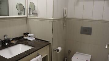 Un baño con lavabo, espejo, inodoro y ducha.