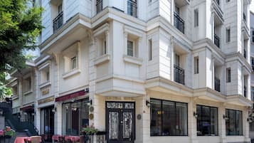 A historic hotel with a classic facade, large windows, and a prominent entrance with ornate ironwork.