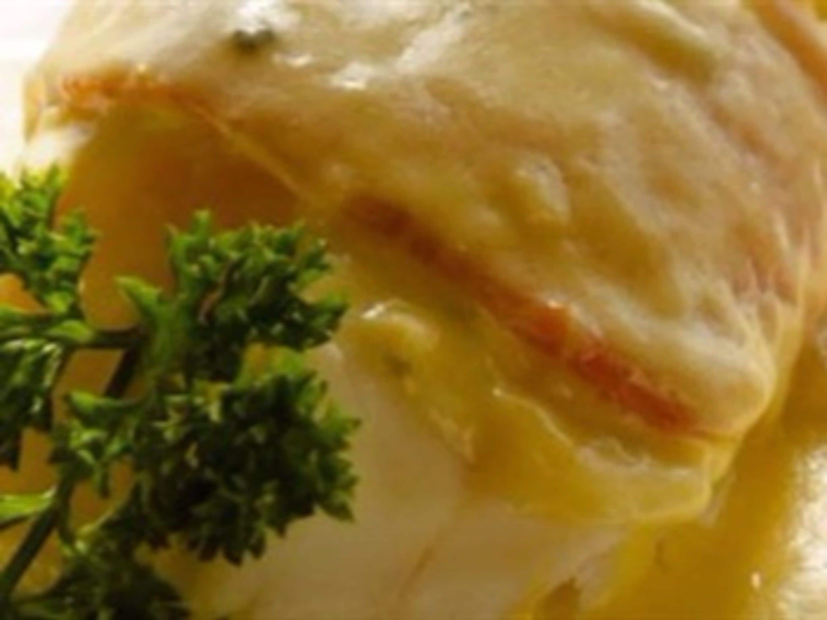A close-up of a creamy dish with a golden-brown crust, garnished with parsley.