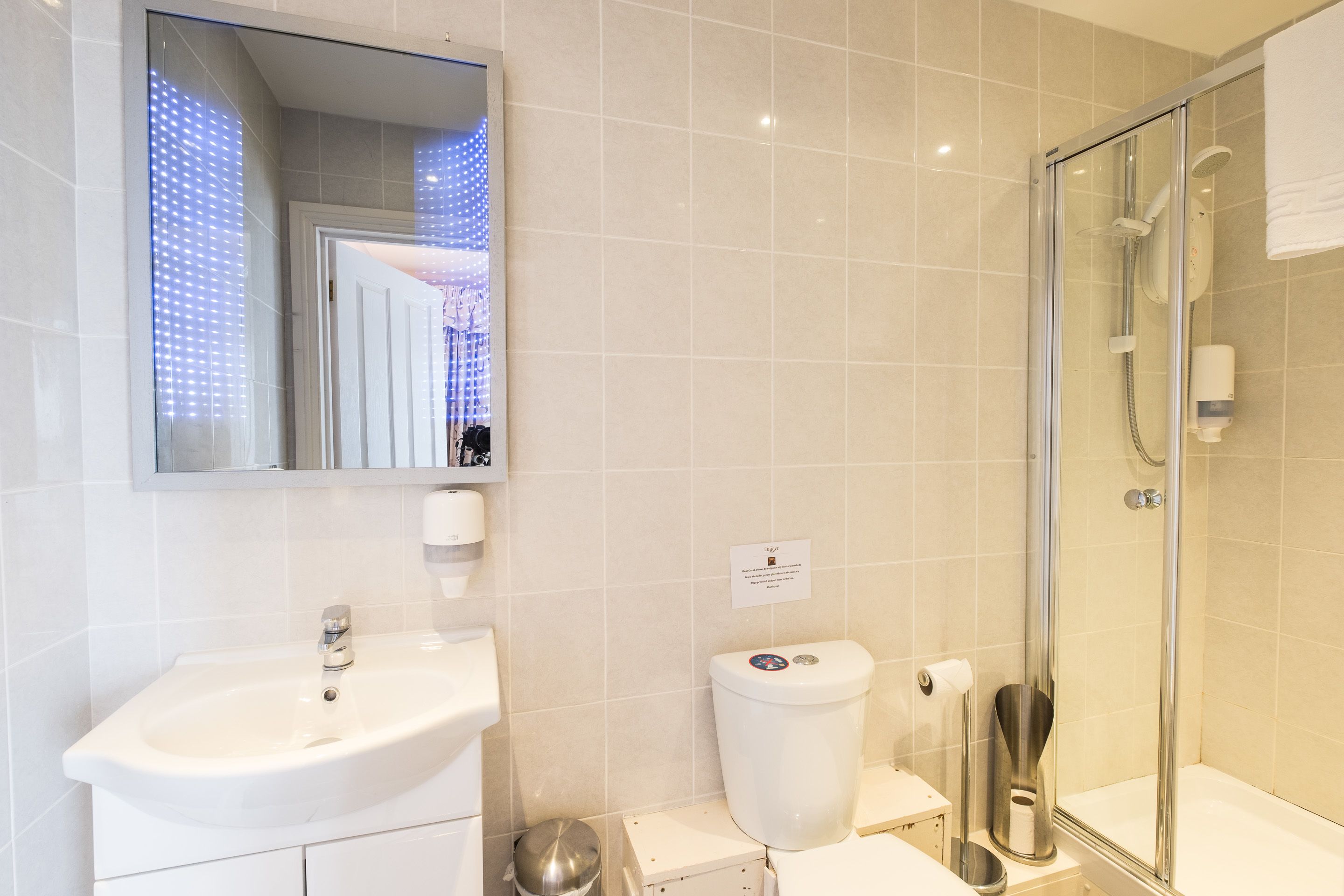 A modern bathroom with a sink, toilet, and glass-enclosed shower.