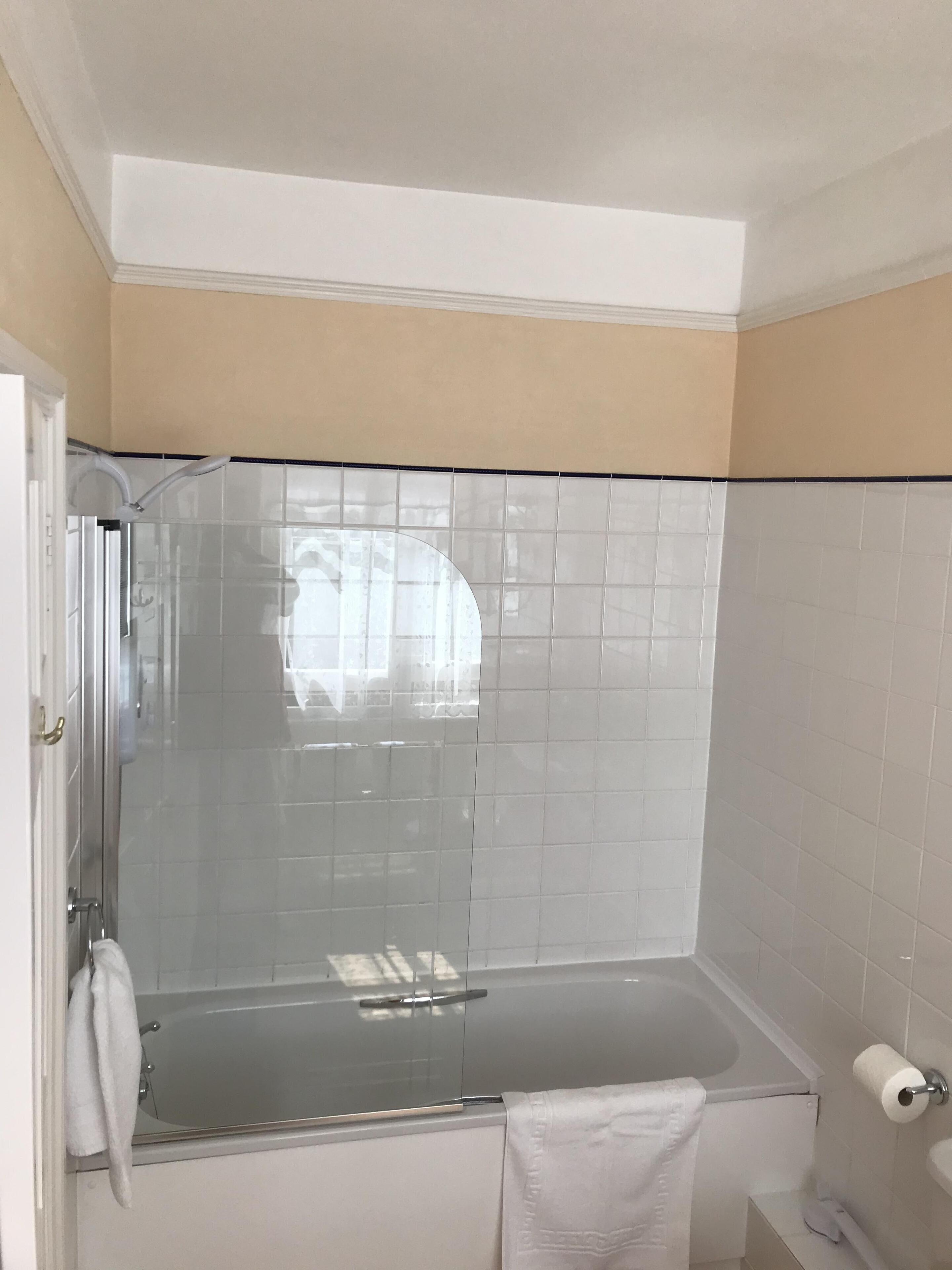 A bathroom with a glass-enclosed shower, a bathtub, and a toilet.