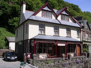 A two-story building with a red-framed porch and a sign reading "Lords Down House." - Lorna Doone House (Lynmouth)
