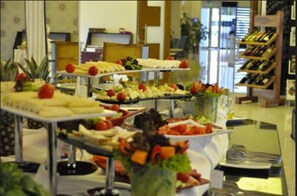 Un buffet proposant une variété de plats, notamment des fruits et des fromages, disposés sur plusieurs tables de service.